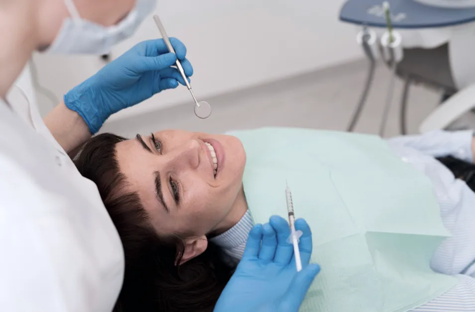 Tu boca susurra, ¿la escuchas? Por qué el dentista no puede esperar 2 Una joven paciente sentada en el sillón dental y la dentista revisa sus dientes