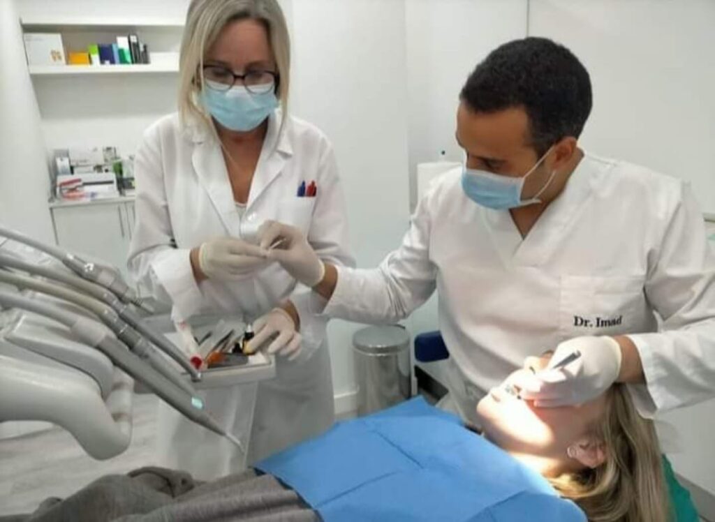 Dos dentistas de la Clínica Dental Nueva Ciudad realizando un tratamiento a una paciente