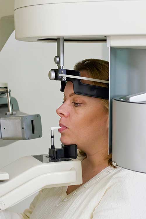 Recuperación tras la extracción de las muelas del juicio: tiempos, consejos y qué comer 2 Una mujer a la que están haciendo una radiografía dental.